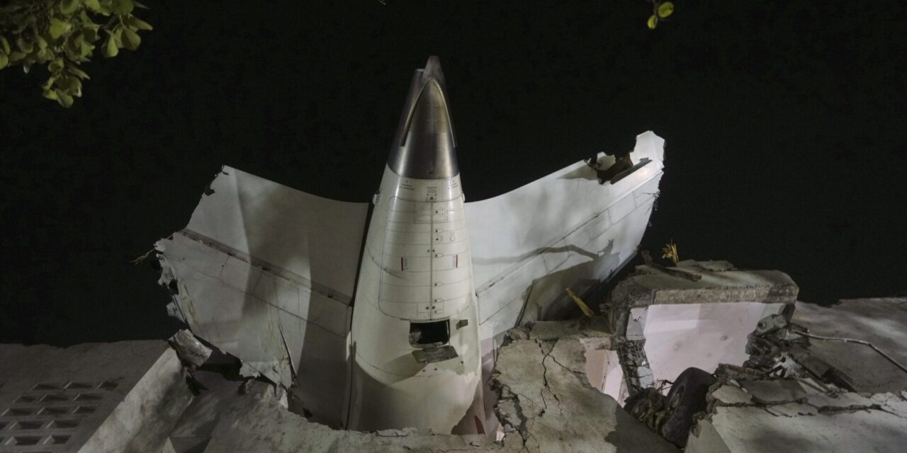 AP PHOTO: Air India plane’s tail juts from a building