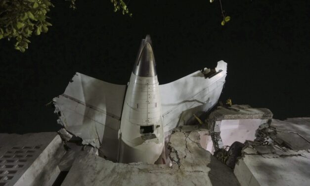 AP PHOTO: Air India plane’s tail juts from a building